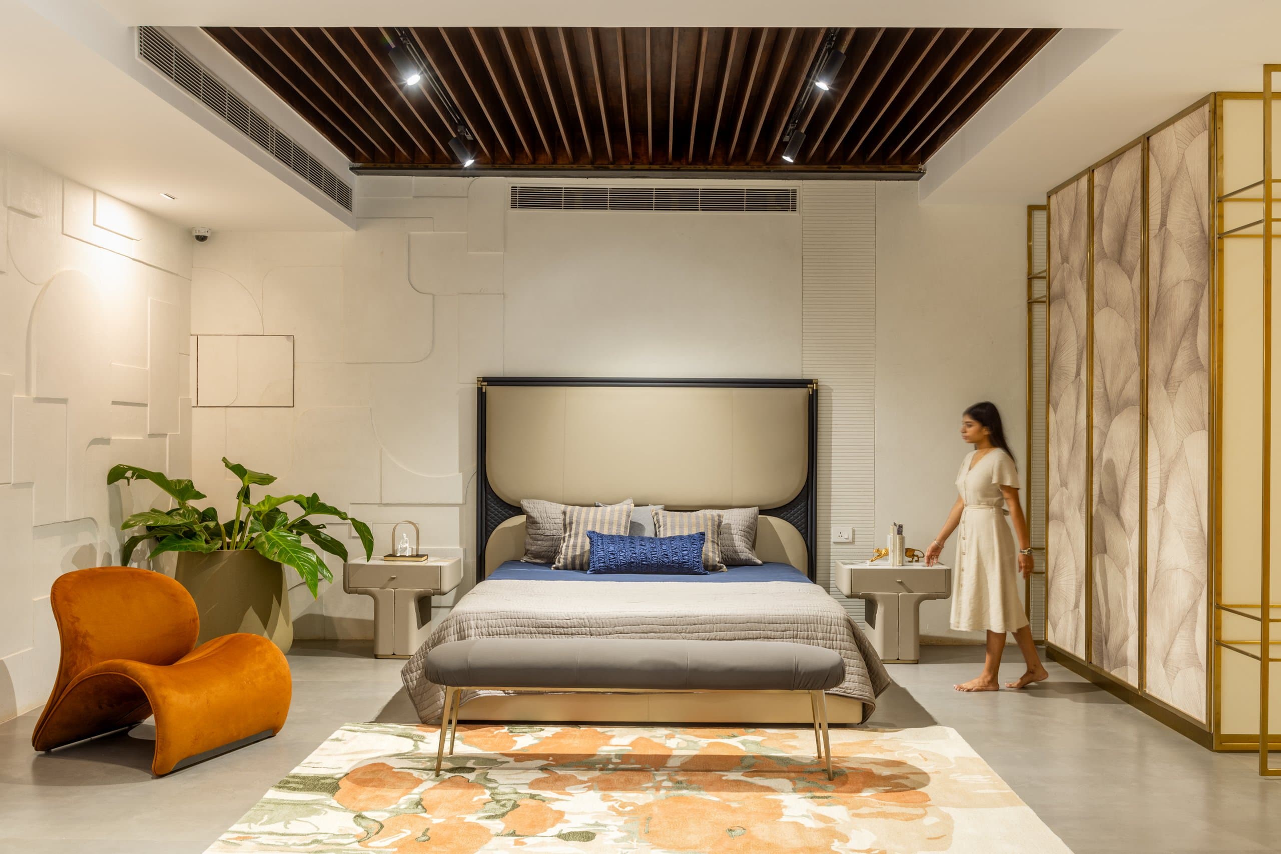 Bedroom vignette under a timber-slat canopy with a brass screen.