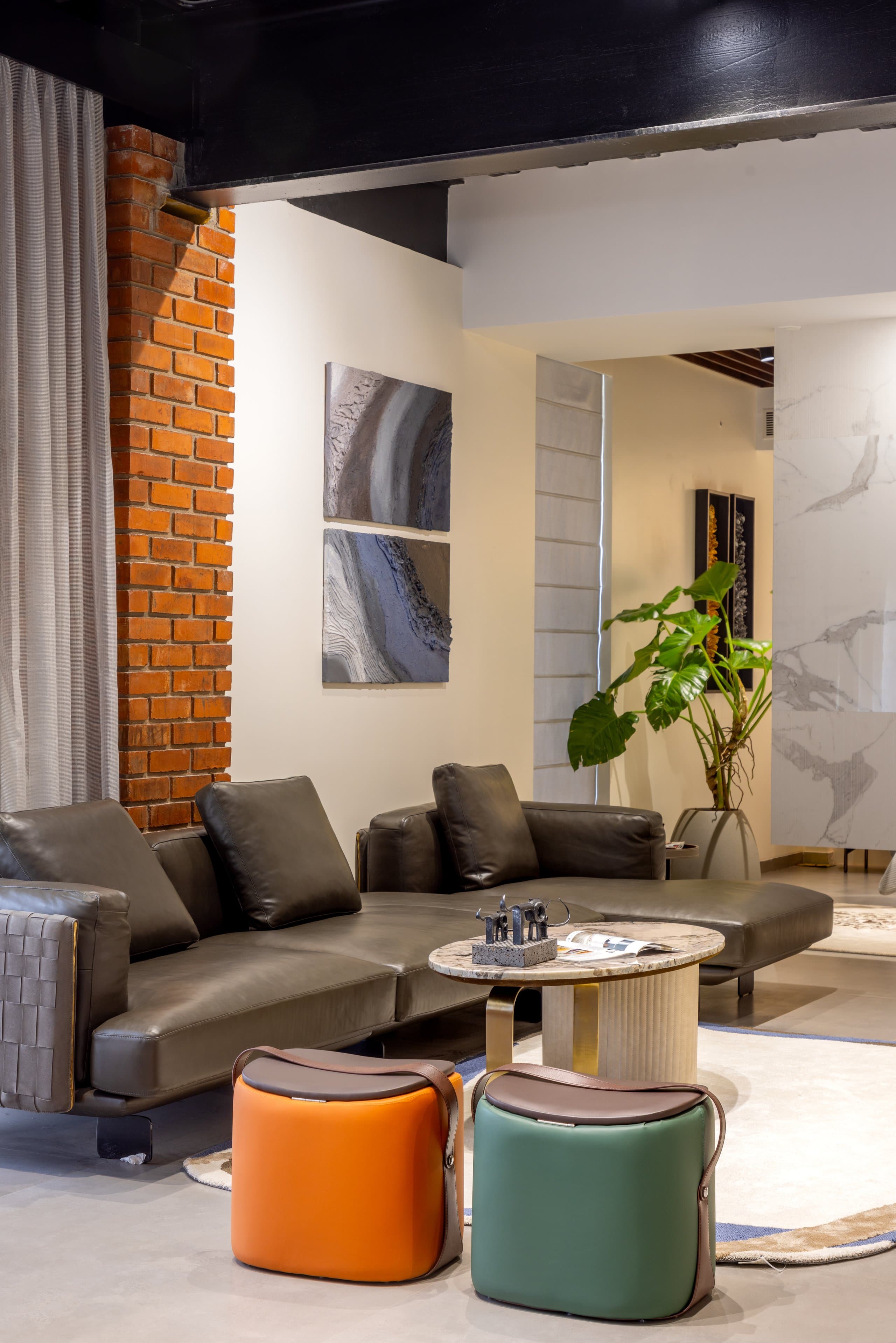 Leather sofa with orange and green poufs — the store's repeated pairing.