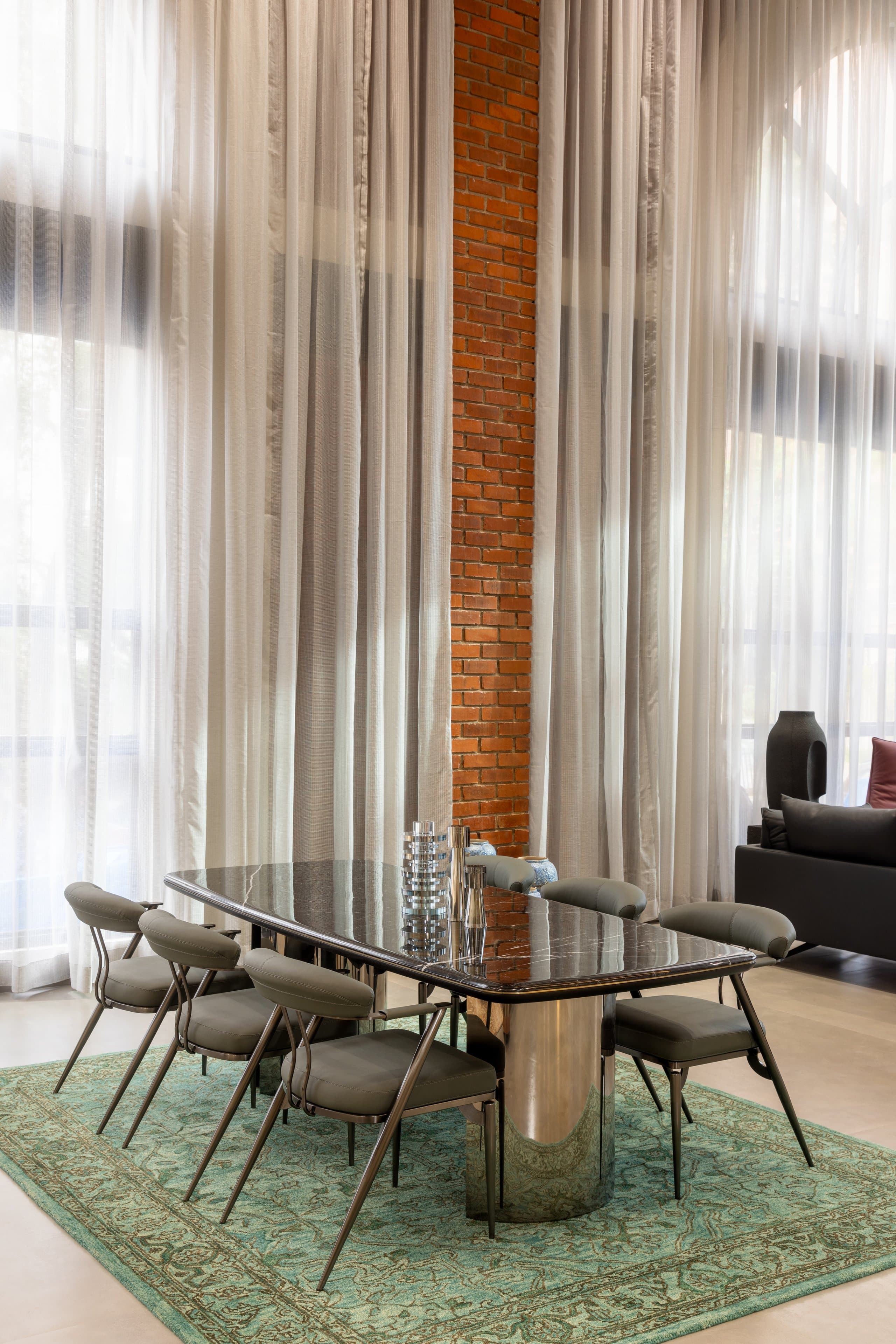 Dining territory: dark marble table and chairs held by a teal rug.