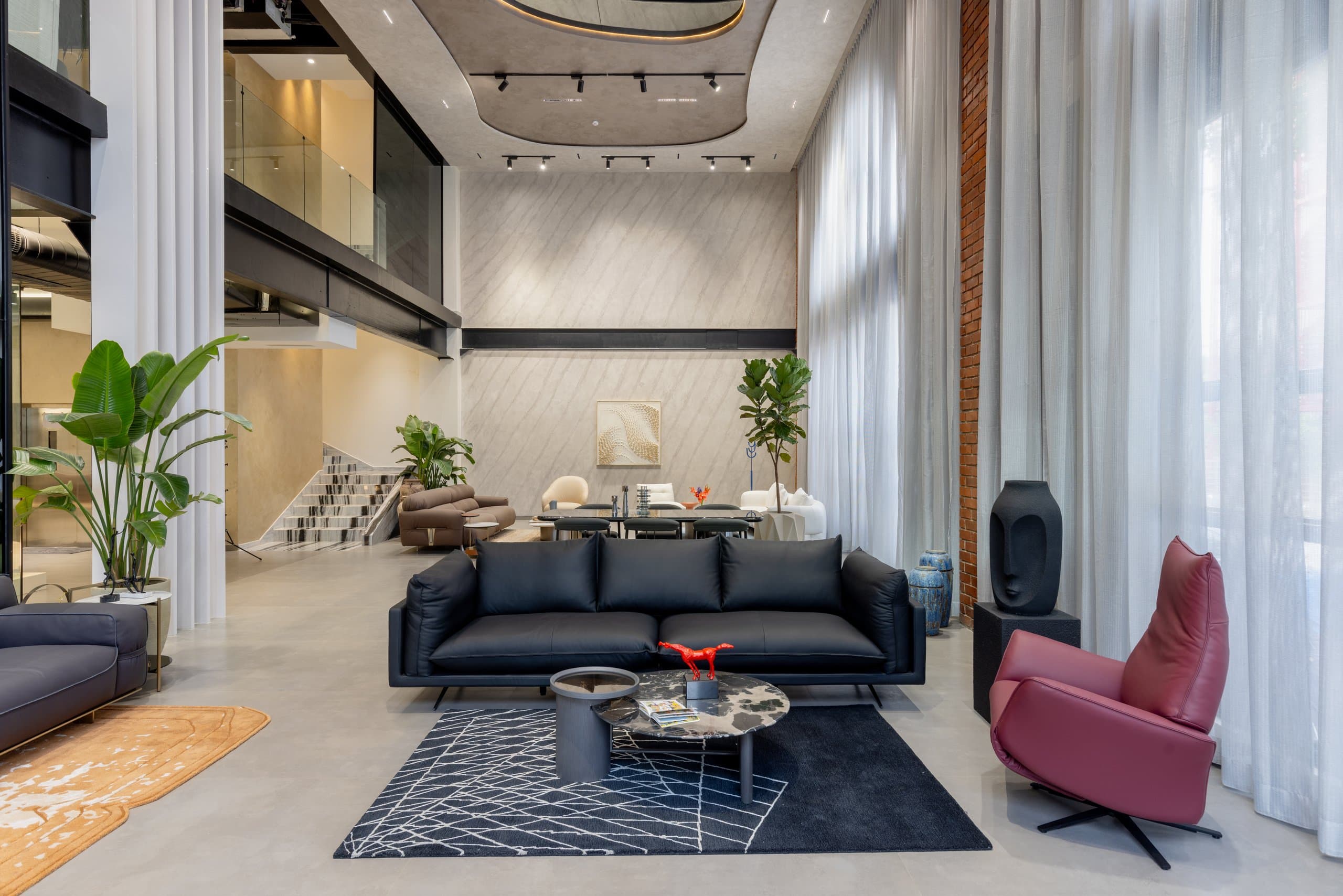 Navy sofa and plum armchair on a navy rug, an amber rug beyond.