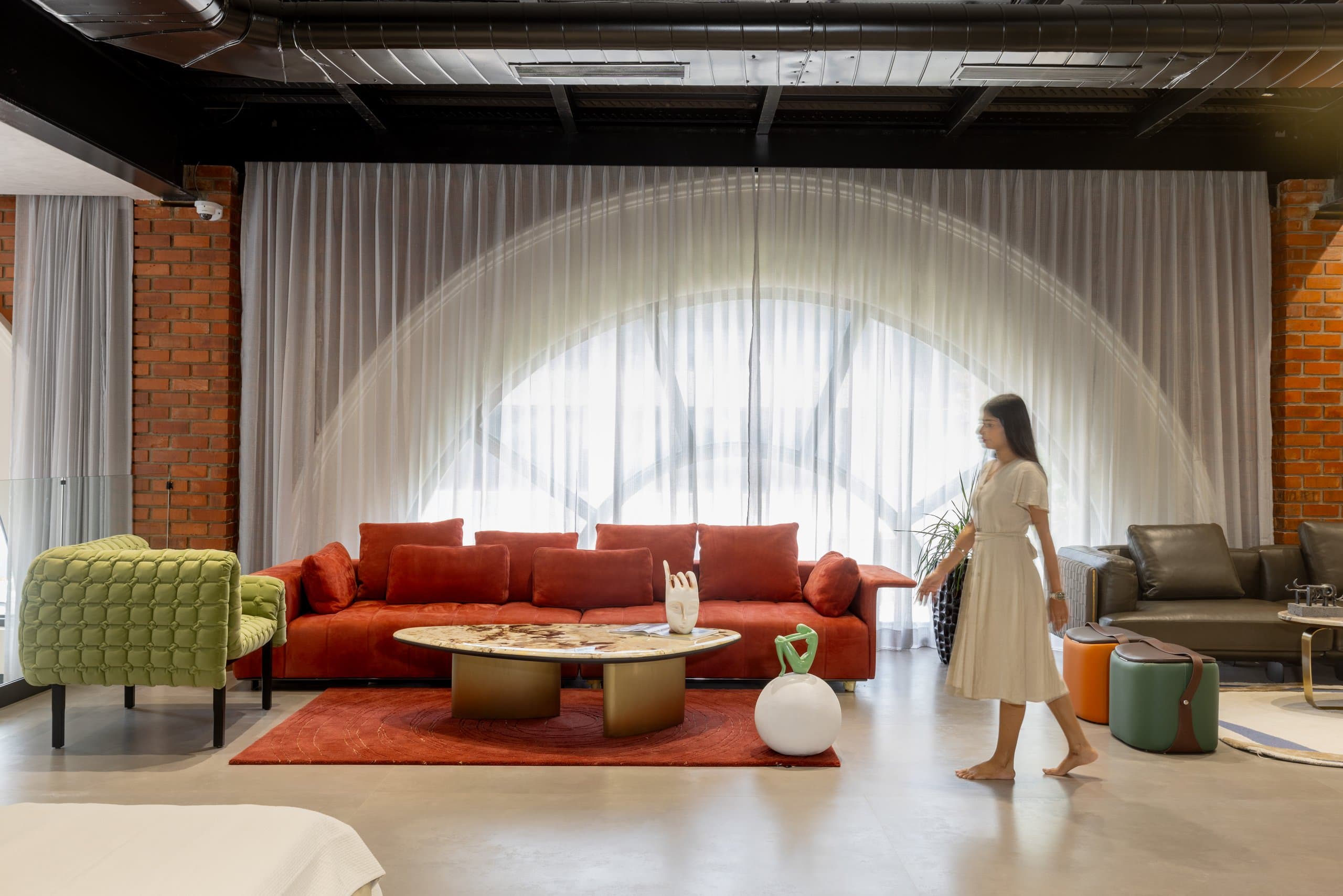The red room: red sofa, cushions and rug stopping at the rug's edge, a figure passing.